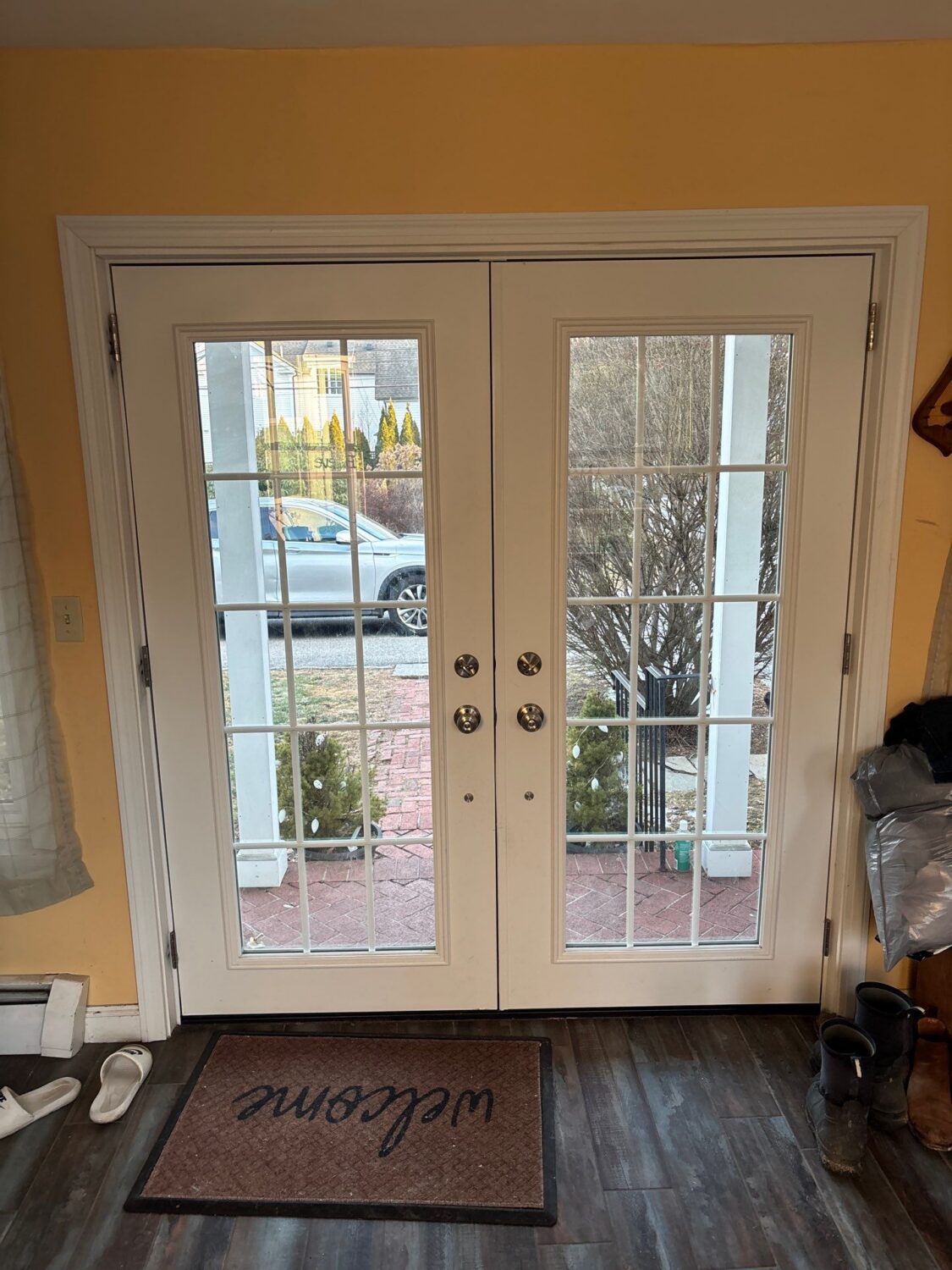 White French patio doors with divided lites installed in a Massachusetts home, showcasing one option homeowners compare when researching French doors vs sliding glass doors for style, ventilation, and accessibility.