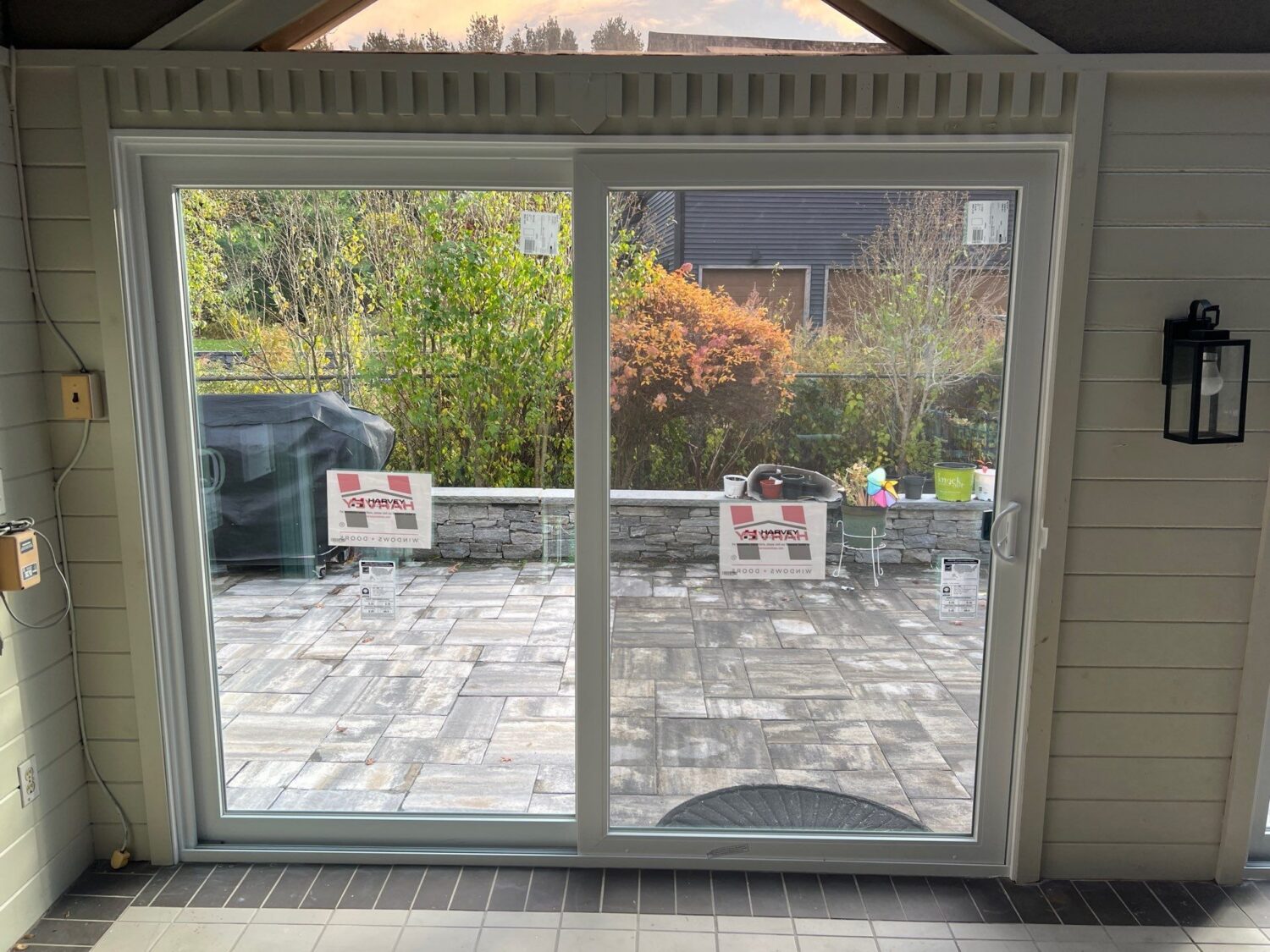 New Harvey sliding patio door overlooking an outdoor living space, demonstrating the space-saving design homeowners evaluate when comparing French doors vs sliding glass doors for energy efficiency and comfort.
