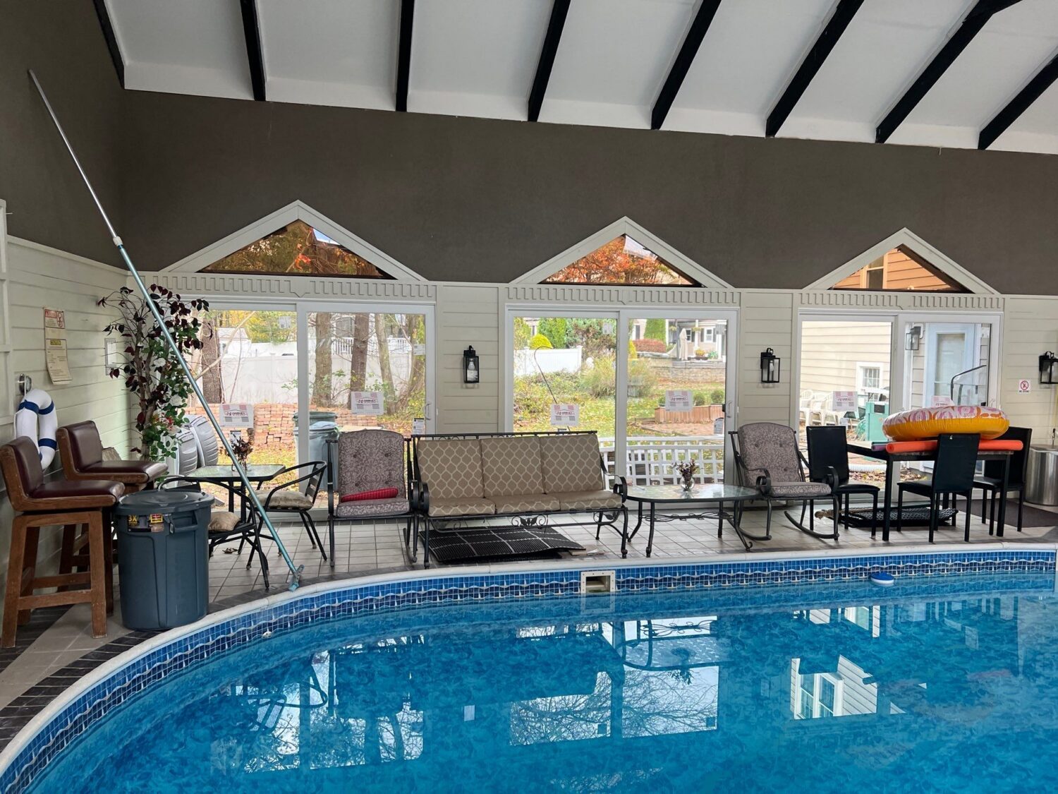 Interior view of an enclosed pool area featuring large Harvey sliding patio doors that maximize natural light and energy efficiency while creating easy access to outdoor spaces.