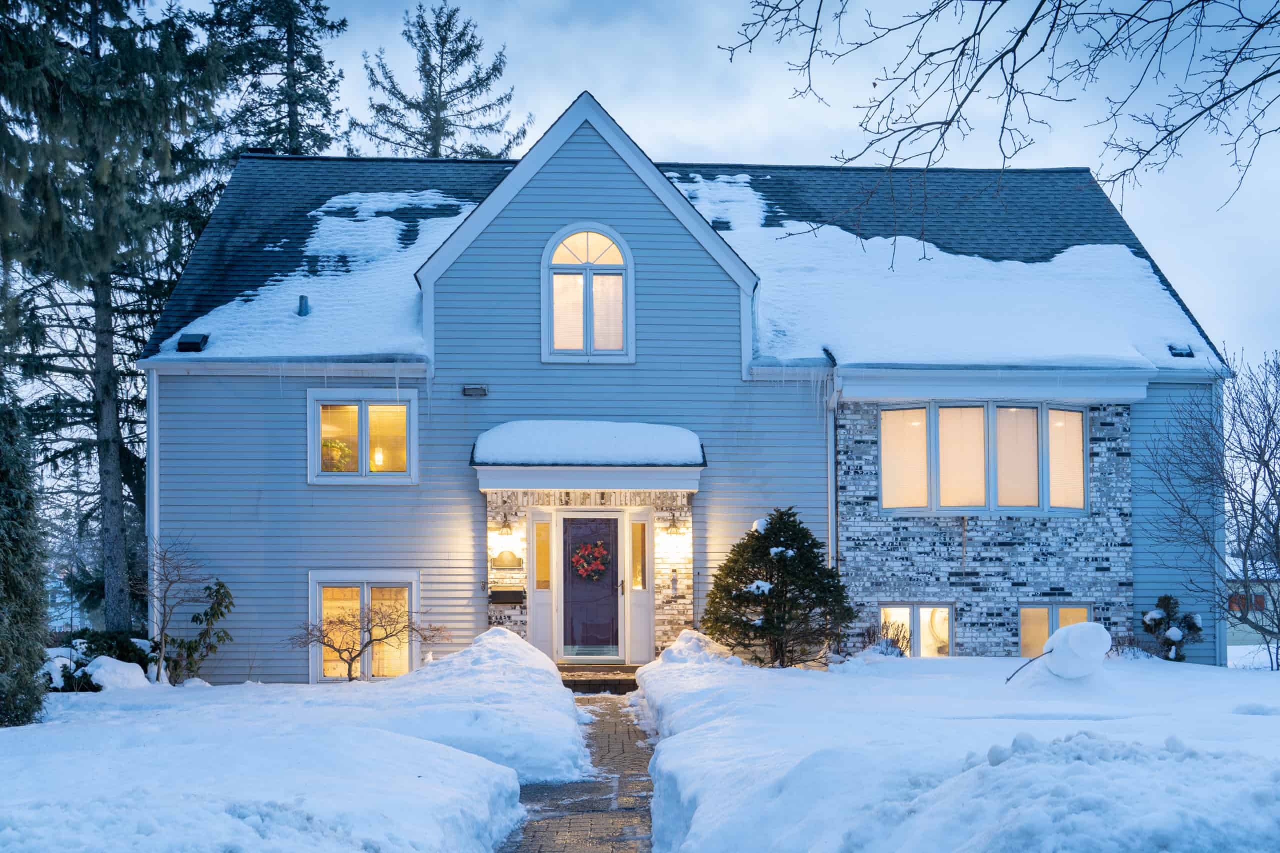 two story house in massachusetts in the winter covered in snow