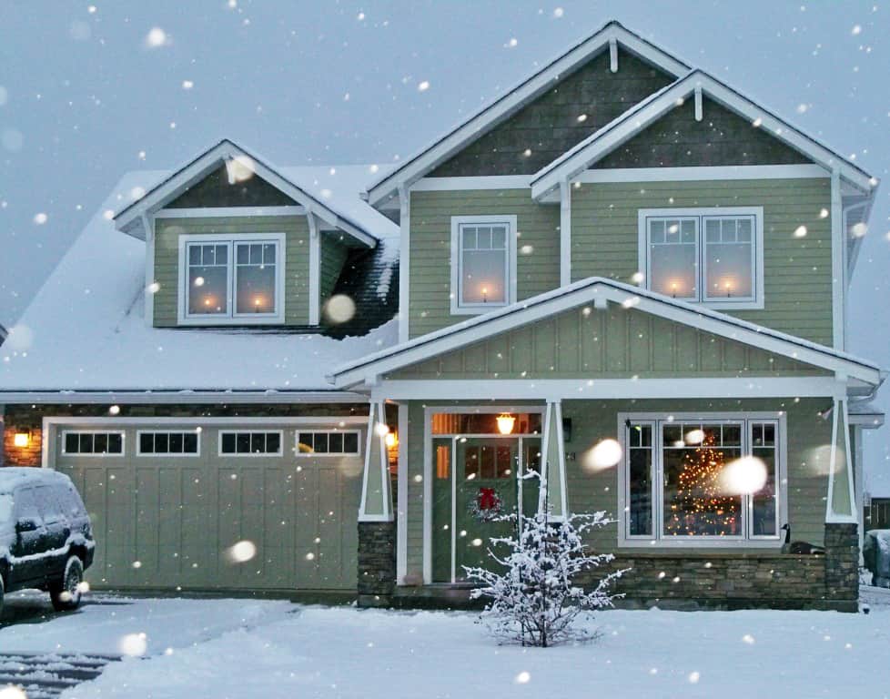 green home in the winter while snowing showing off sidings
