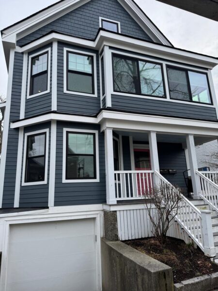 Contemporary black window frames installed on gray siding exterior
