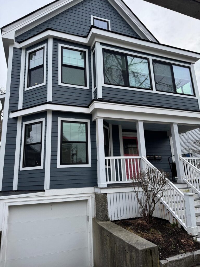 Contemporary black window frames installed on gray siding exterior