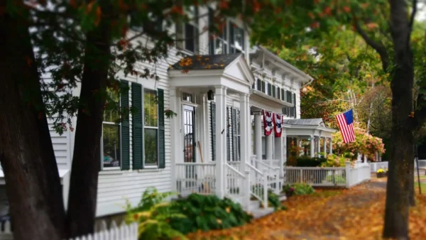 White colonial home protected with house wrap for vinyl siding in a New England neighborhood