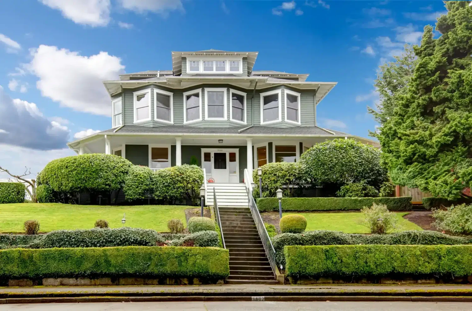 A large Beverly home features multiple bay windows, upper-story windows, and a traditional wraparound porch. In addition to improving comfort and sound control, replacement windows can help address why do windows get foggy in summer by reducing air leakage and moisture intrusion.