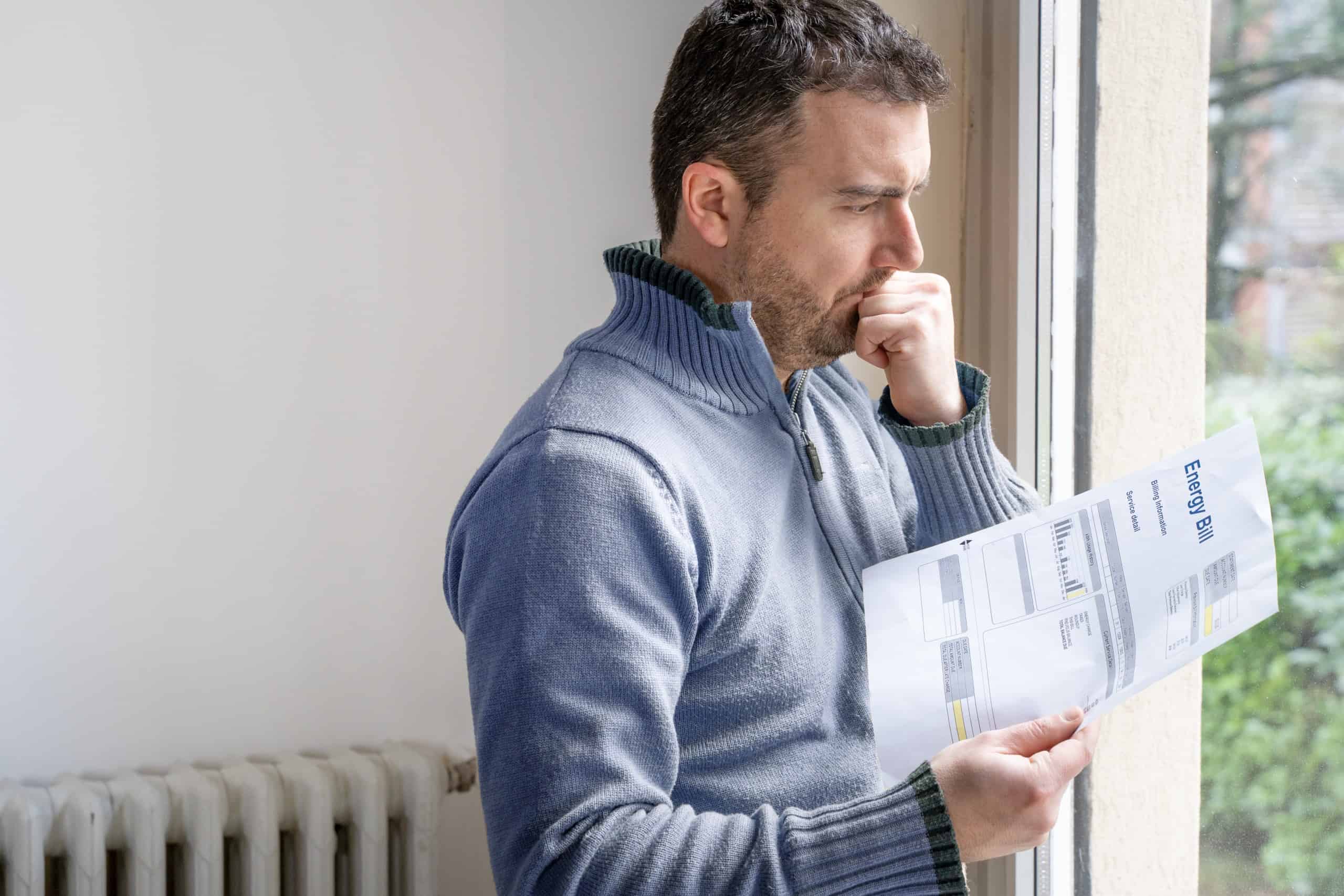 Man checking energy bill and thinking why energy bill is high