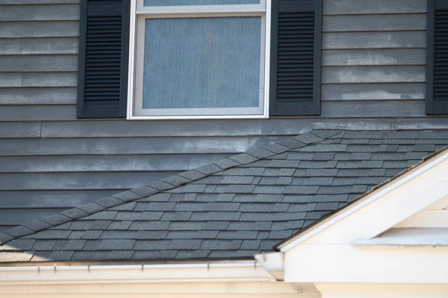 Close-up of faded and deteriorating siding showing signs homeowners may confuse when asking does vinyl siding fade.