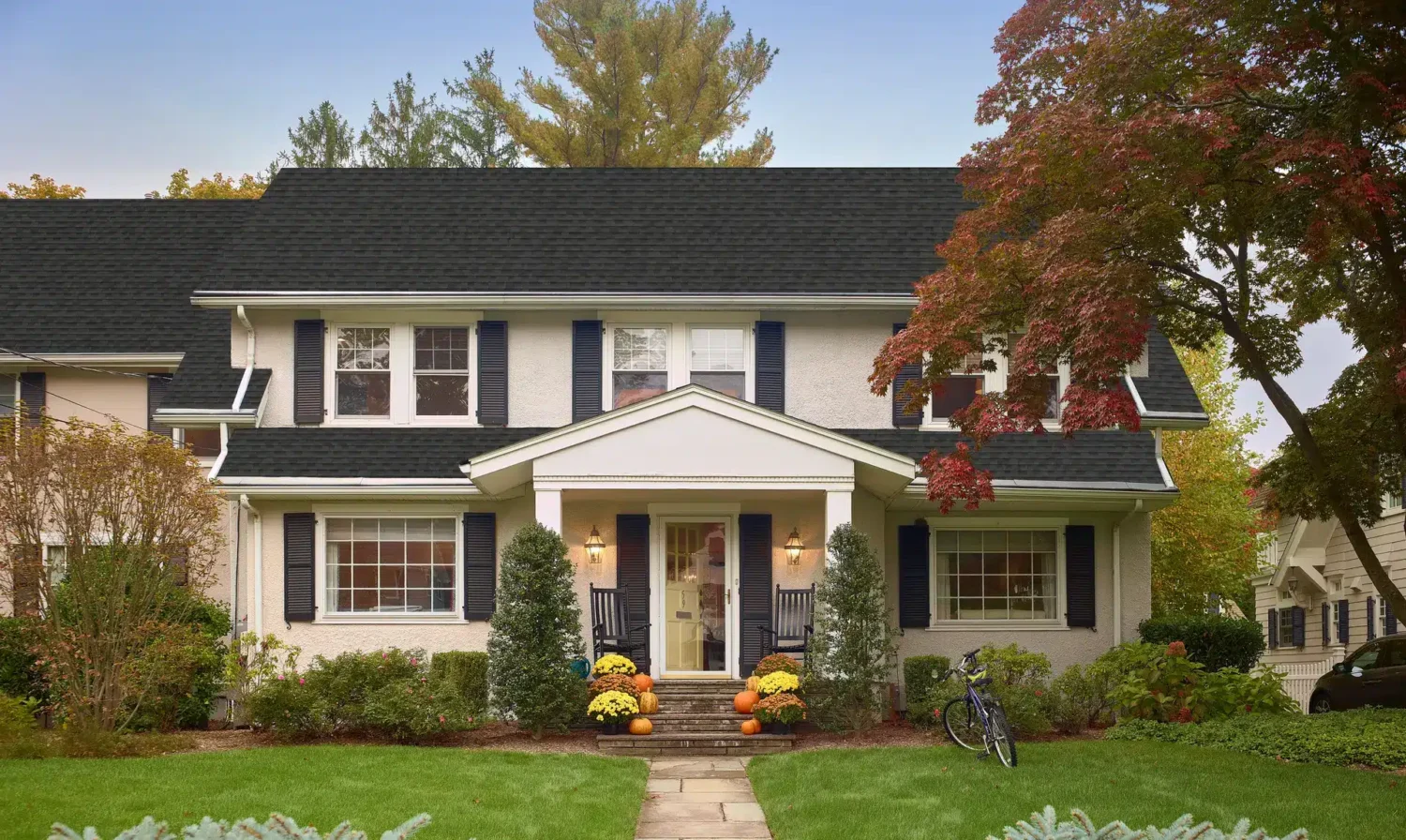 Colonial home decorated for fall with pumpkins, mums, and double-hung windows, ready for cold weather in Wenham, North Shore.
