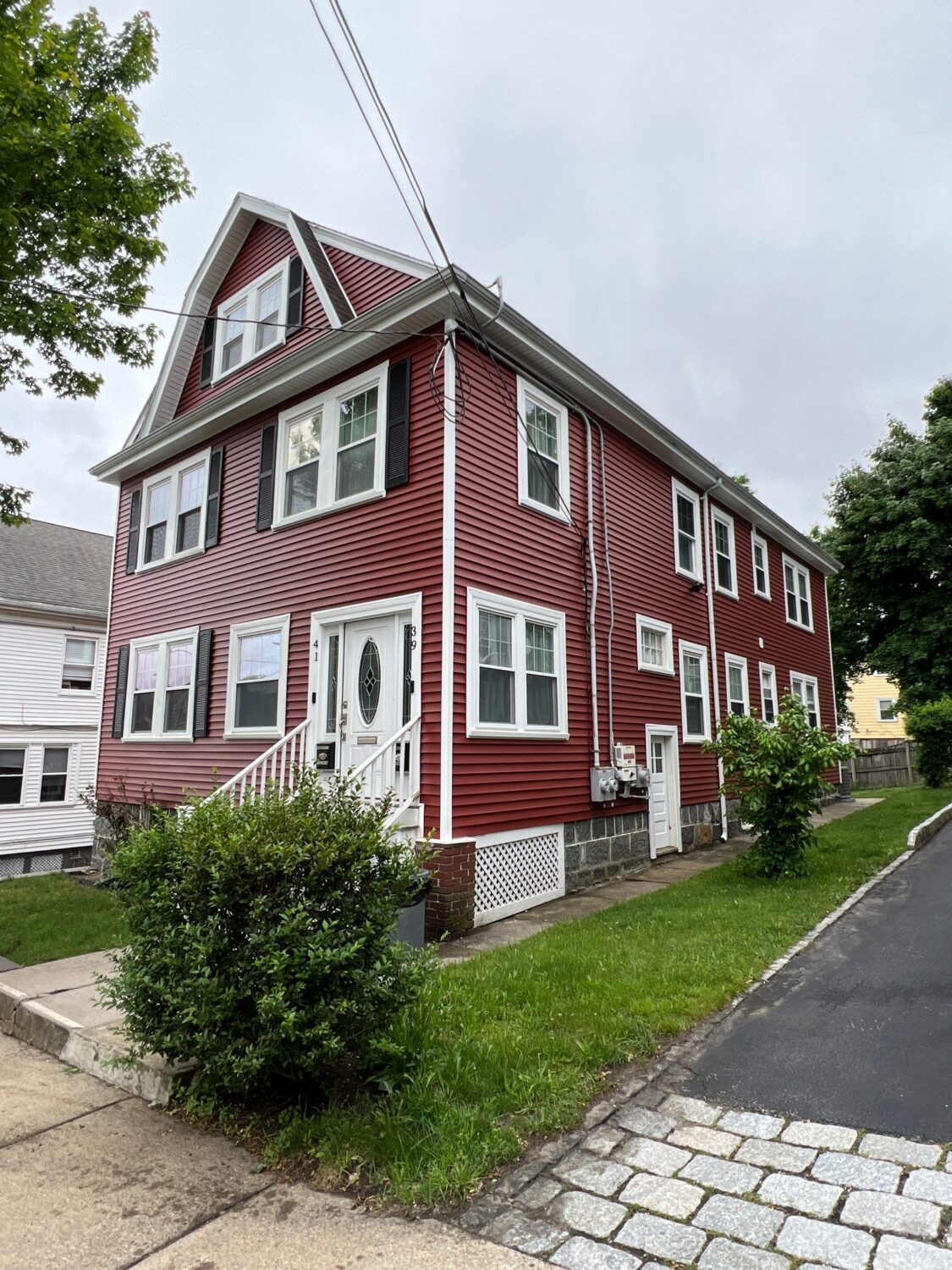 Red vinyl siding installation in Greater Boston demonstrating vibrant color that answers does vinyl siding fade.