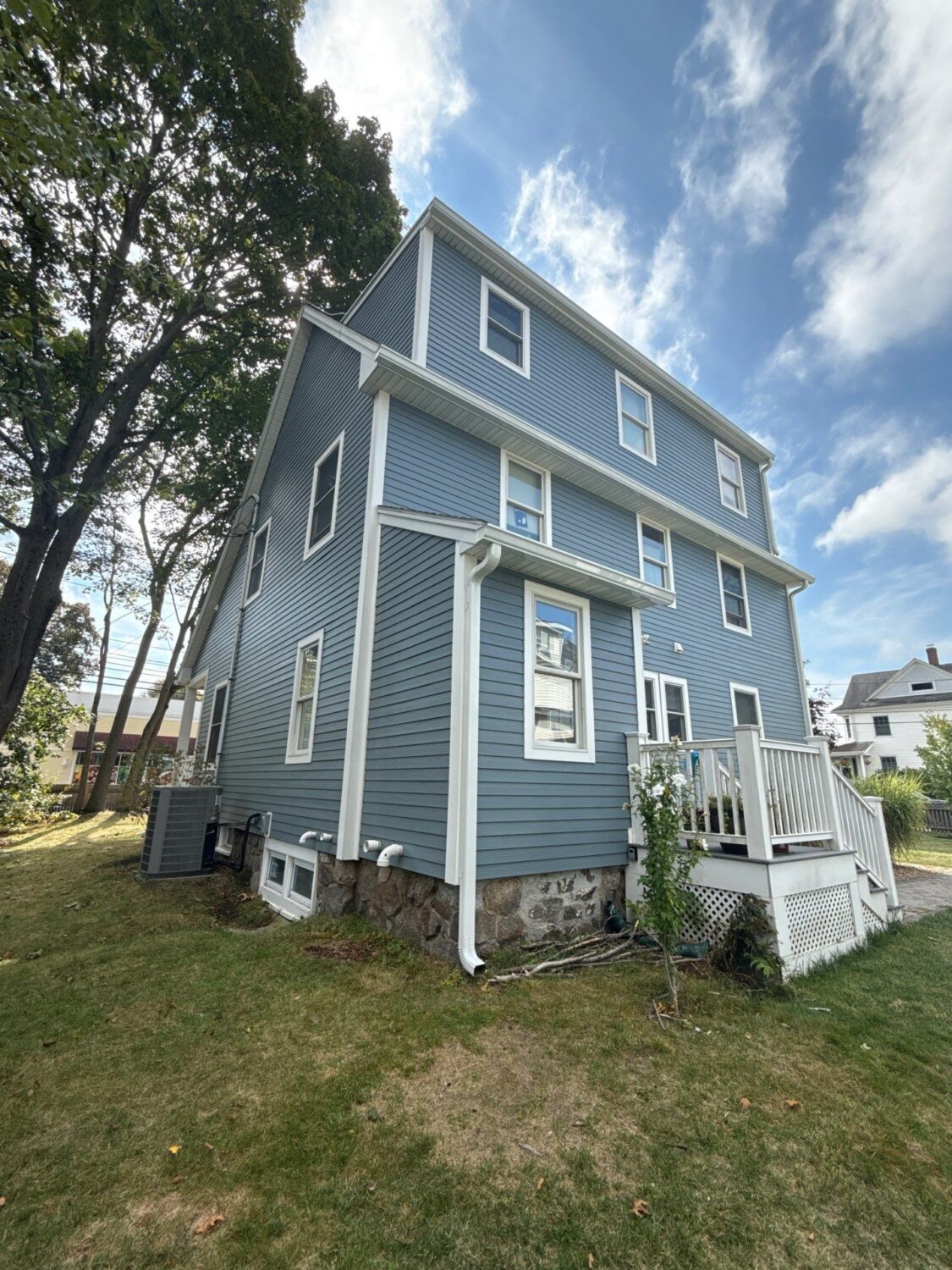 Modern energy efficient siding wraps this three-story home with durable protection against moisture and the elements. The insulated siding improves thermal performance while creating a clean, low-maintenance exterior with crisp white trim.
