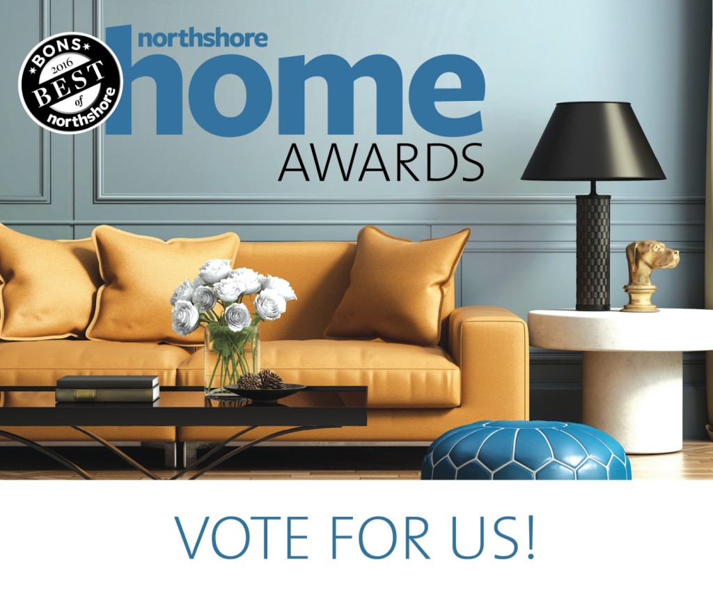 A modern living room with a yellow sofa, blue ottoman, black lamp, and white flowers. Text reads North Shore home AWARDS and VOTE FOR US! A Best of North Shore badge is in the top left corner.