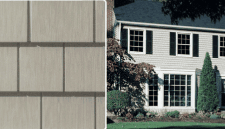 A two-story house with gray siding and black shutters, surrounded by shrubs and trees. Next to the house is a close-up of a gray shingle sample.