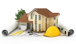 A model house sits on architectural blueprints, surrounded by construction tools, a yellow hard hat, and a small tree, highlighting home improvement projects and thoughtful construction planning inspired by insights from the 2016 Cost vs Value report.