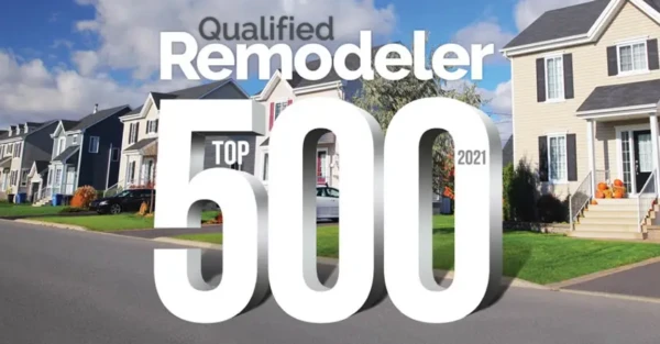 A suburban neighborhood with several two-story houses under a partly cloudy sky features the text Qualified Remodeler Top 500 2021 in bold. Renowned for excellence, Coastal Windows & Exteriors leads the way as a top exterior remodeling contractor in New England.