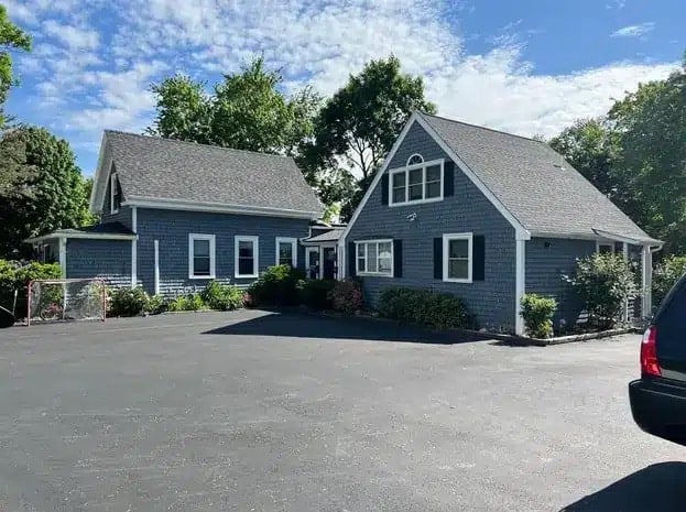 Blue-gray home featuring one of the most popular shingle colors for New England roofs paired with matching exterior siding.