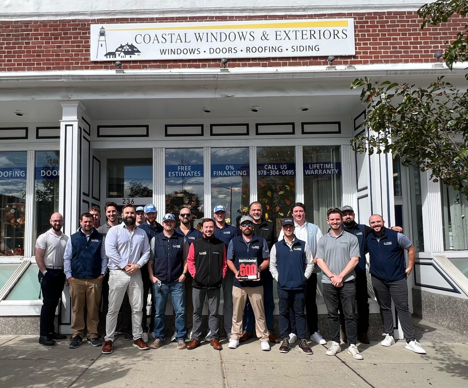 Coastal Windows & Exteriors team celebrating Top 500 Remodeler recognition outside their Beverly MA showroom.