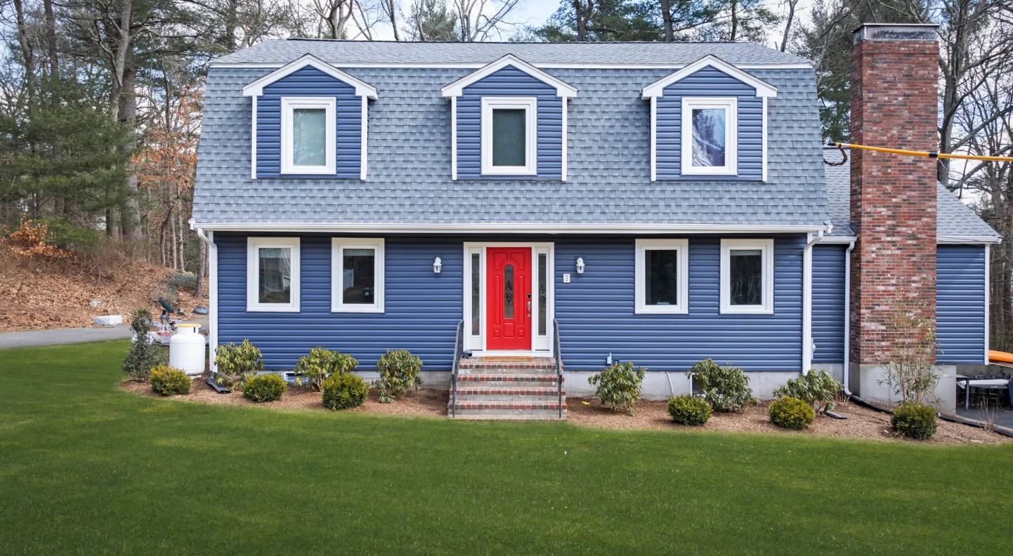 Norfolk MA home with new indigo blue vinyl siding and red entry door installed by Coastal Windows & Exteriors.