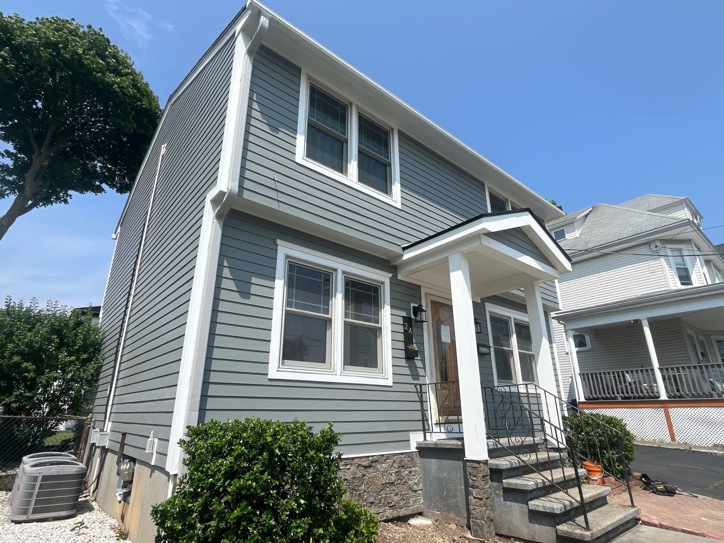 Modern home with gray siding demonstrating is it worth it to replace siding through enhanced appearance and long-term durability. White trim and updated exterior details create a clean finished look.