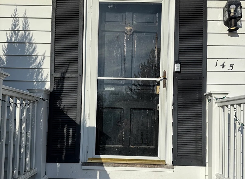 Old worn entry door before replacement during an Exterior remodeling sale in Beverly MA.