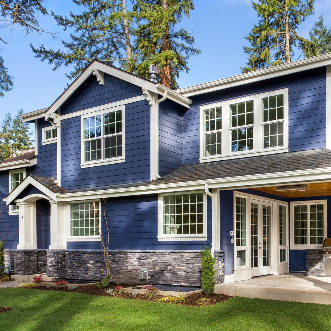 Blue home exterior with entry doors featured in doors faq guide.