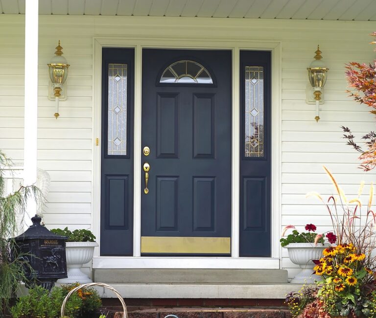 A dark blue front door with decorative sidelights and polished hardware creates an elegant entrance. Secure screen door installation in Bristol NH can provide added protection while allowing light and airflow into the home.