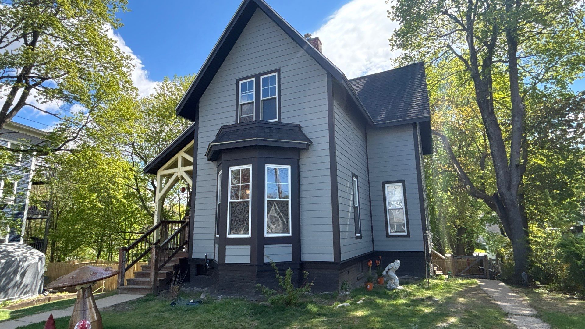 A black-trimmed bay window anchors the front of this steep-gabled Gardner Victorian, now clad in Gray Slate fiber cement under a dark shingle roof. Homeowners comparing James Hardie certified installers in Gardner MA can see the finished detail here.