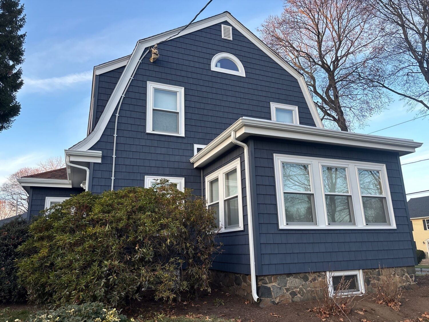 Blue vinyl shake siding on a Massachusetts home highlighting durability concerns homeowners compare when researching James Hardie vs vinyl siding Massachusetts.