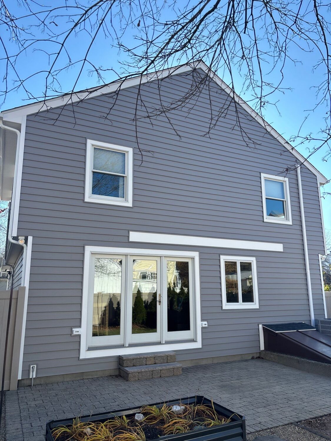 Gray vinyl siding installation on a North Shore Massachusetts home showcasing modern curb appeal and energy-efficient exterior remodeling.