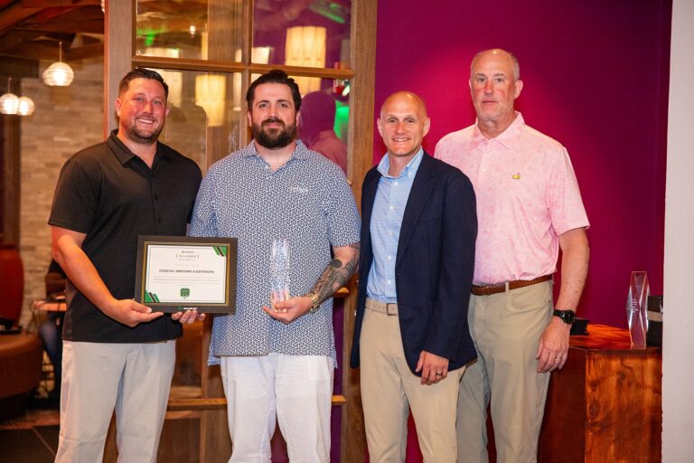 Coastal Windows & Exteriors representatives pose with a James Hardie recognition certificate and award at a 2026 industry event.