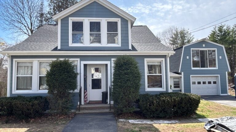 Haverhill, MA cape with refreshed blue siding, crisp white trim, and a gray shingle roof, an example of a coordinated exterior renovation.