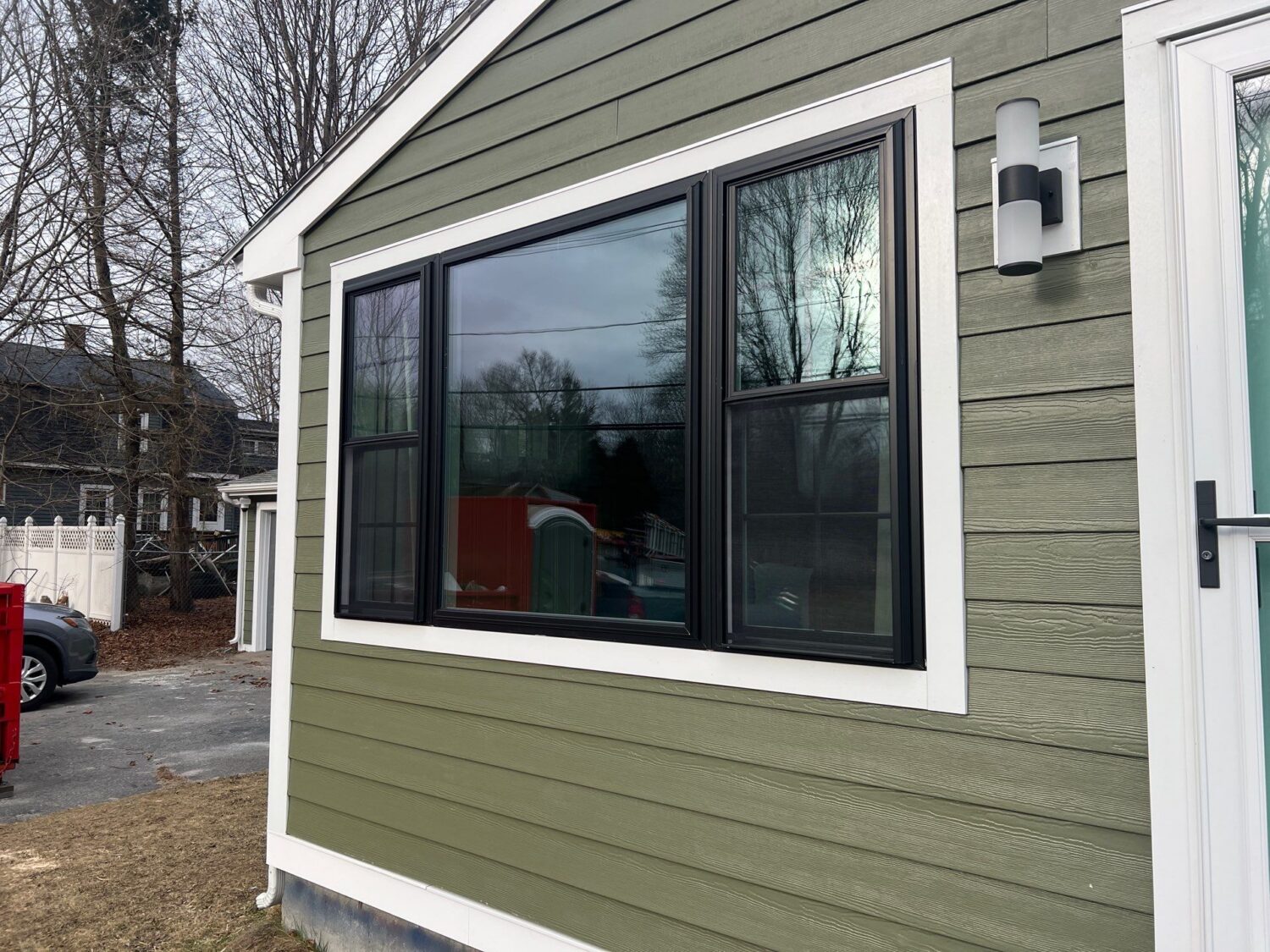 Low-maintenance fiber cement siding and black replacement windows in Newton, MetroWest by Coastal Windows & Exteriors.