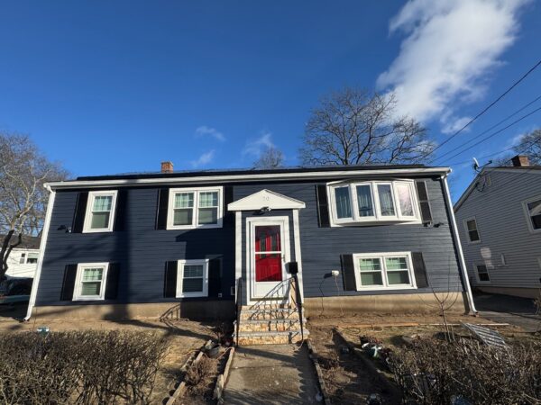 Siding replacement in Quincy, Greater Boston with navy siding and white trim by Coastal Windows & Exteriors.