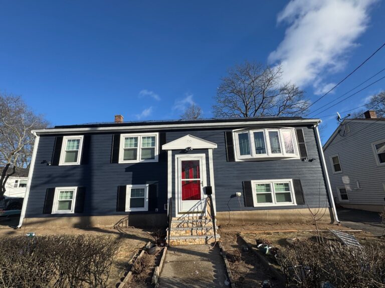 Siding replacement in Quincy, Greater Boston with navy siding and white trim by Coastal Windows & Exteriors.